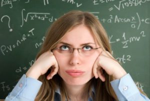 Studentka przy tablicy z matematycznymi wzorami